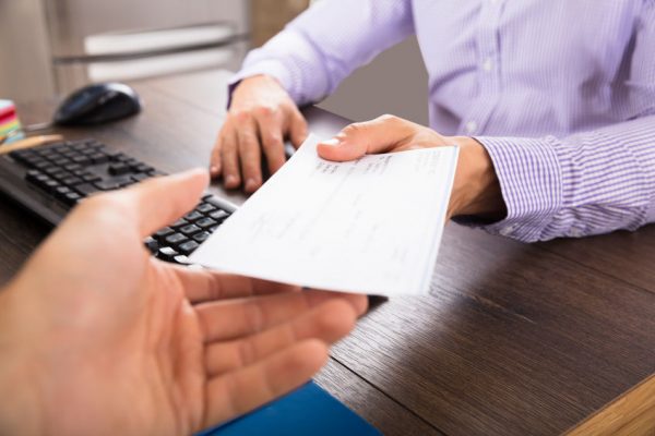 Businessman Giving Cheque To Her Colleague