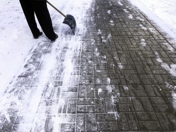 Worker sweep snow from road in winter