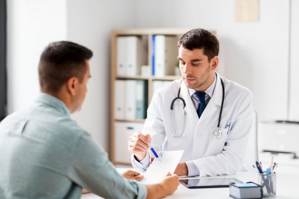 doctor showing prescription to patient at hospital