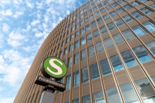 Low angle view of Friedrichstrasse railway station sign against modern office building