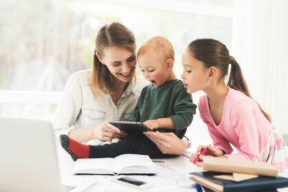 A woman works during maternity leave at home. A woman works and cares for a children at the same time.