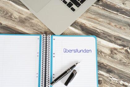 A,Computer,In,Office,And,A,Notebook,With,German,Word
