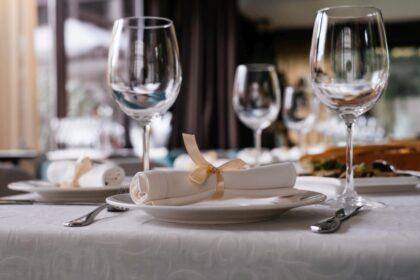 Glasses on restaurant table full of food by window