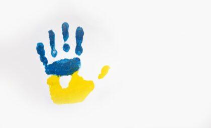 Imprint of child's hand with colors of Ukrainian flag isolated on white background. Copy space