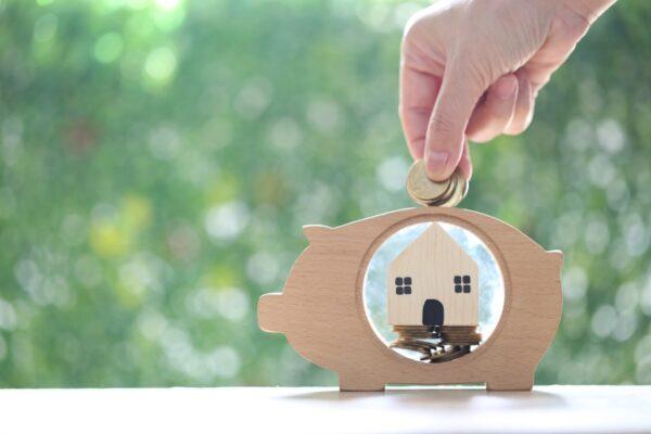 Stack of coins money in piggy bank wood and Model house on natur