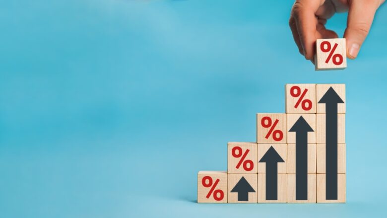Wooden blocks with percentage sign and arrow up, financial growt