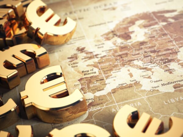 Euro sign on the world map background with DOF effect.