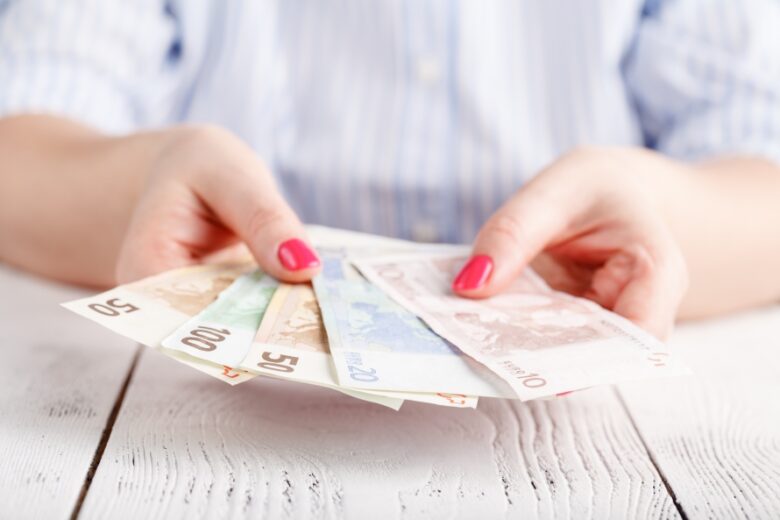 Female hands with banknotes give money