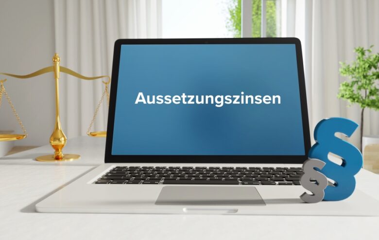 Aussetzungszinsen – Recht, Gesetz, Internet. Laptop im Büro mit Begriff auf dem Monitor. Paragraf und Waage.