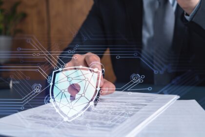 A businessman in formal wear signing the contract to prevent probability of risks in cyber security. Padlock Hologram icons over the working desk.