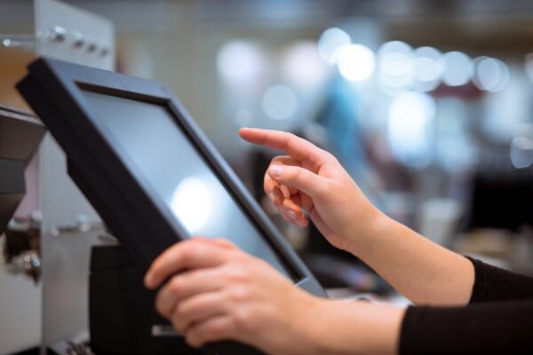 Young woman hand doing process payment on a touchscreen cash reg